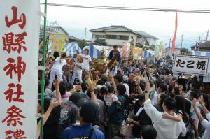 神輿から餅を投げる写真