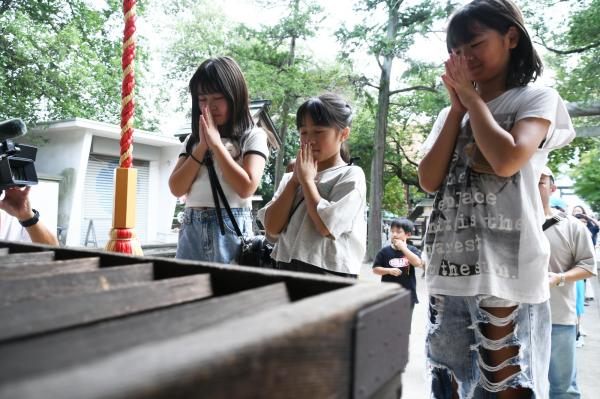 神社でお参りをしている女の子3人の写真