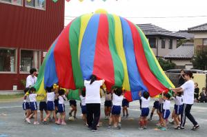 カラフルなパラバルーンで演技する園児