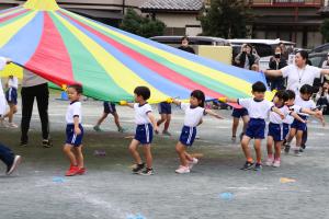 パラバルーンをもって円を描くように歩く園児たち