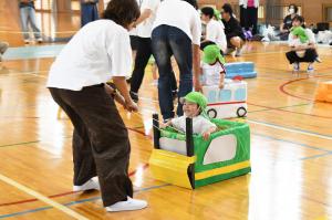 ブルドーザーのそりに乗って運ばれる園児