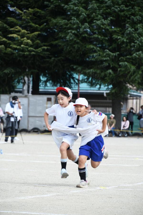 大きなパンツを２人で履いて走っている写真