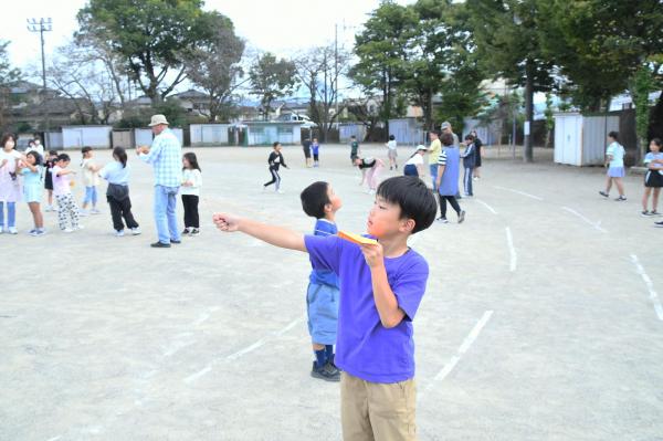 竹とんぼを飛ばす青いティーシャツをきた児童