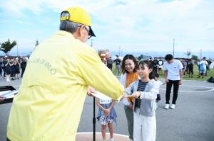 ラジオ体操の街フォトコンテストの表彰状を受け取る女の子