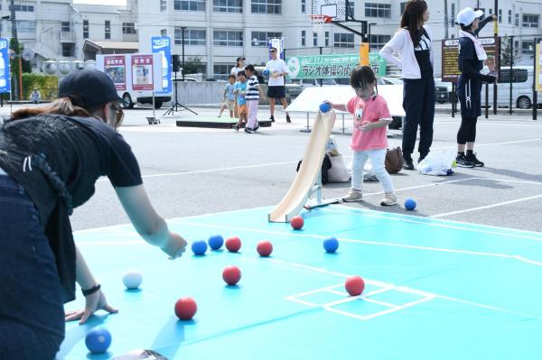 滑り台を使ってボッチャを楽しむ女の子