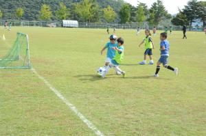 サッカーでゴール向かってシュートをしている写真