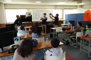 室内でドローンの講習を受ける参加者たち