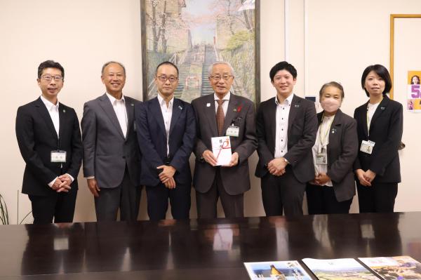 記念写真を撮る市の関係者と明治安田生命保険相互会社のみなさん