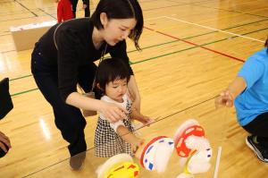 アクリル板に貼ってある綿に触れる子どもの写真