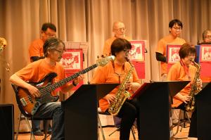 ギターとサックスを演奏するバンドの写真