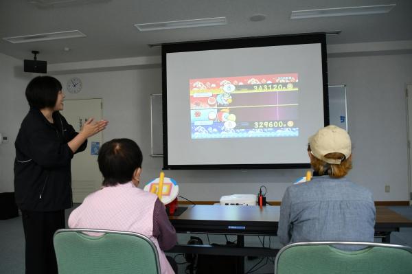 太鼓をリズムよく打つゲームをする参加者たち