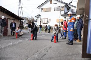 水を消火器から勢いよく出す人の写真