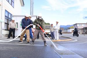 消火栓から放水訓練をする様子の写真