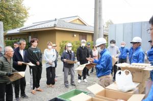 水で膨らむ土のう袋の説明する自治会役員の写真