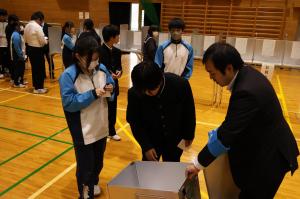 投票箱の中身をチェックする生徒