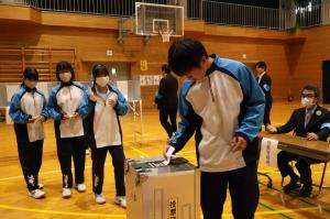 投票箱に票を入れる男子生徒