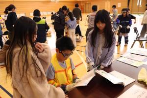 高齢者疑似体験、老眼になる眼鏡をかけて本を読みます。読みにくそう。