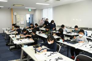 講師の先生に教わりながら書く様子