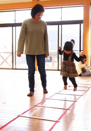 床に置かれたラダーひもをピョンピョン飛び跳ねる練習