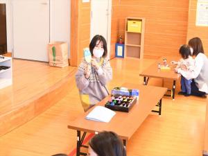 でんでん太鼓の説明を先生がする様子