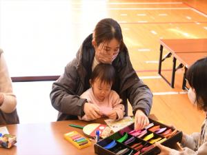 でんでん太鼓に張り付ける色紙を選んでいる様子