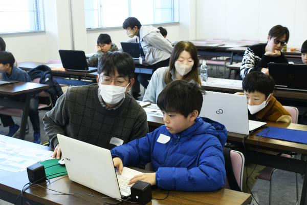 親子でパソコンに向かって操作している写真