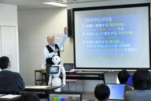 講師がスライドを使って説明している写真