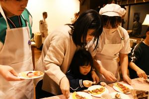 クレープにトッピングをする親子