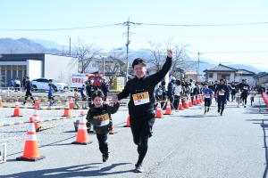 手を挙げてゴールする親子