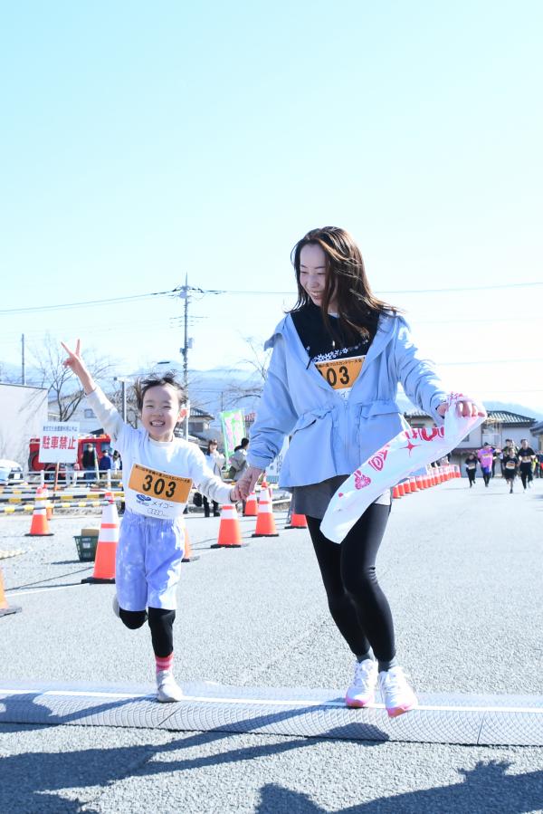 ピースしてゴールする親子