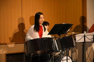 スティールパンを演奏する白い服を着た女性