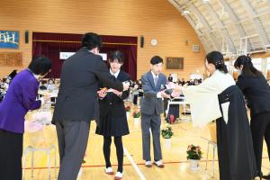 退場する際に先生から花を受け取る卒業生