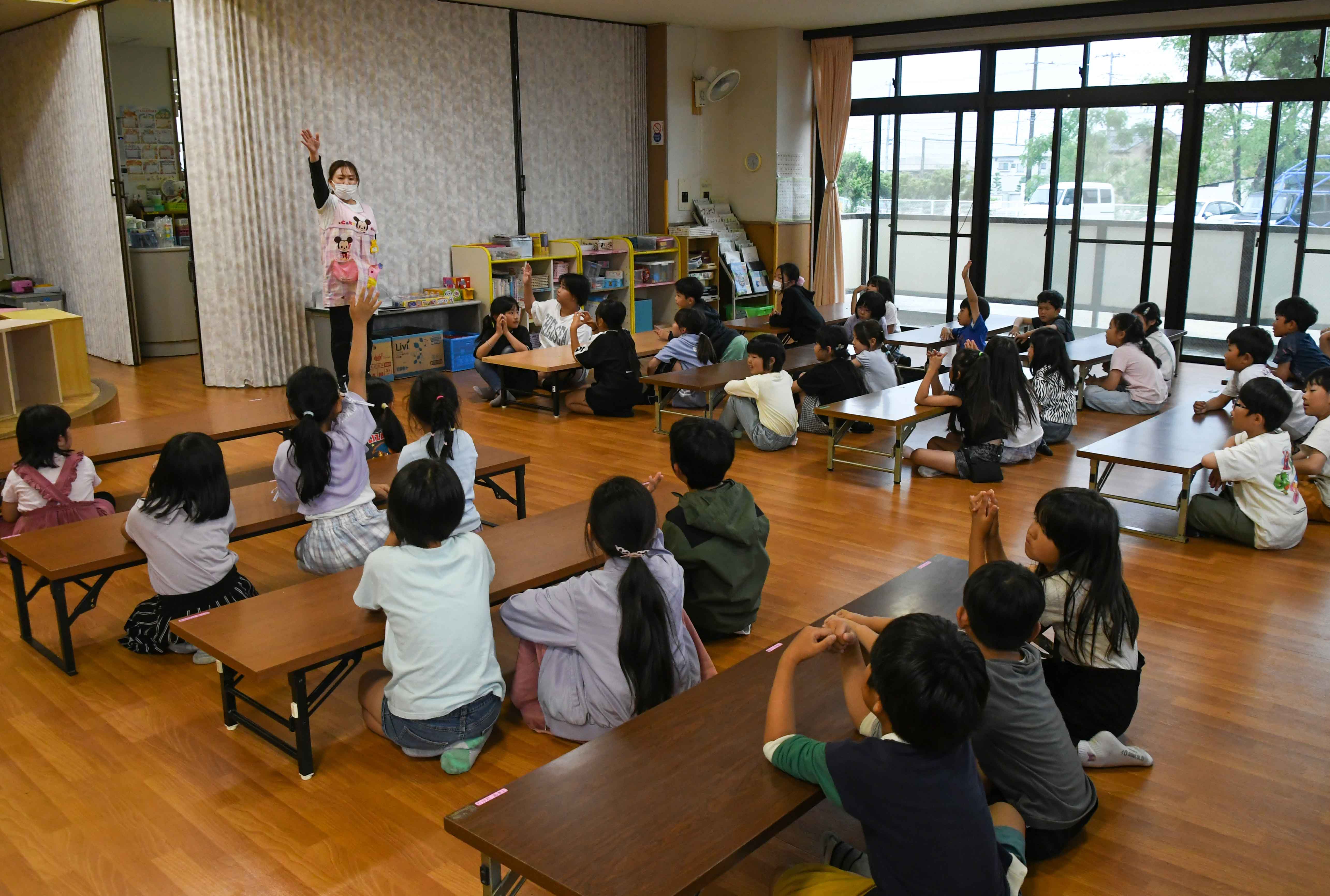 先生の話を聞く子どもたち