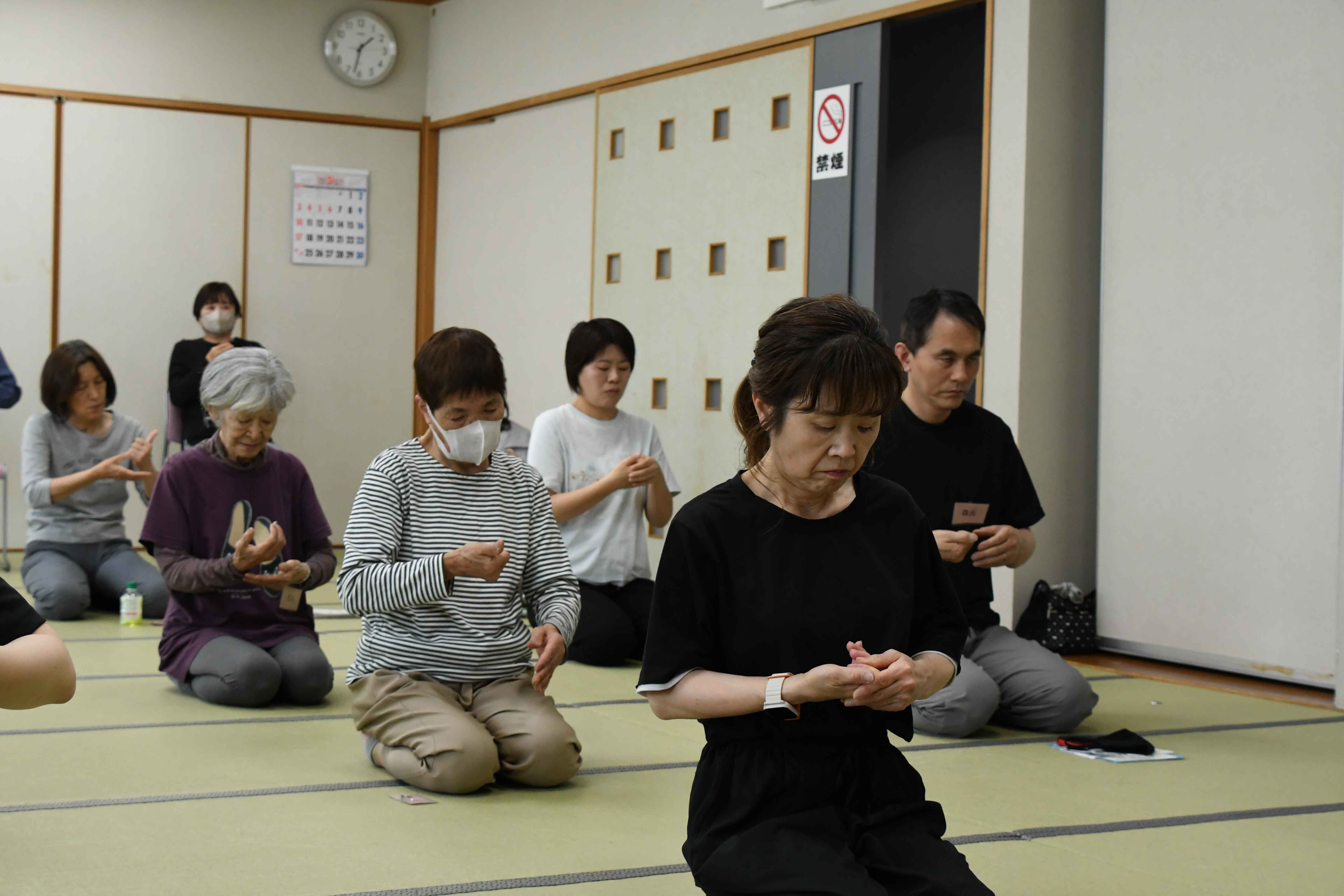 指の体操をする参加者たち