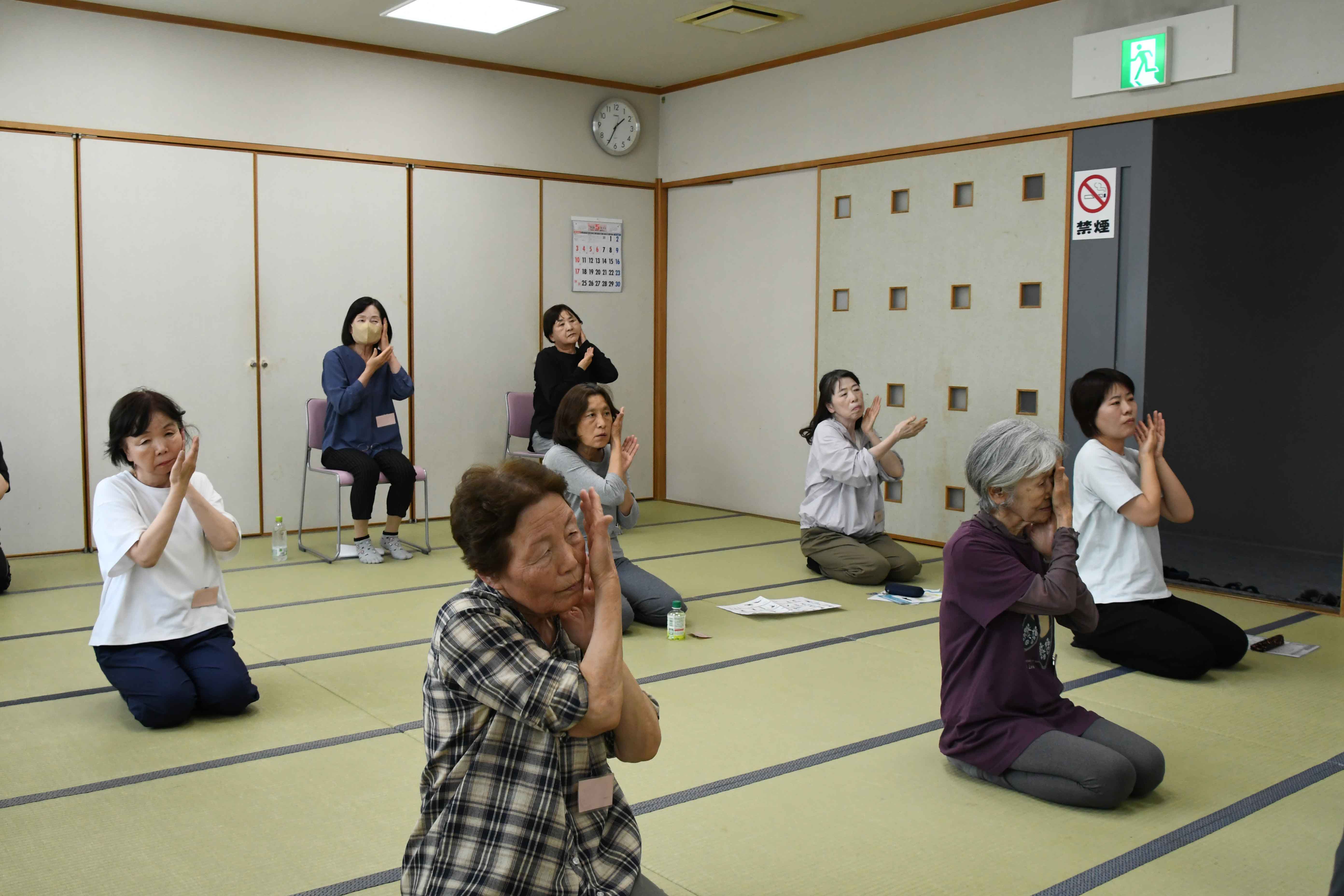 顔の運動をする参加者たち
