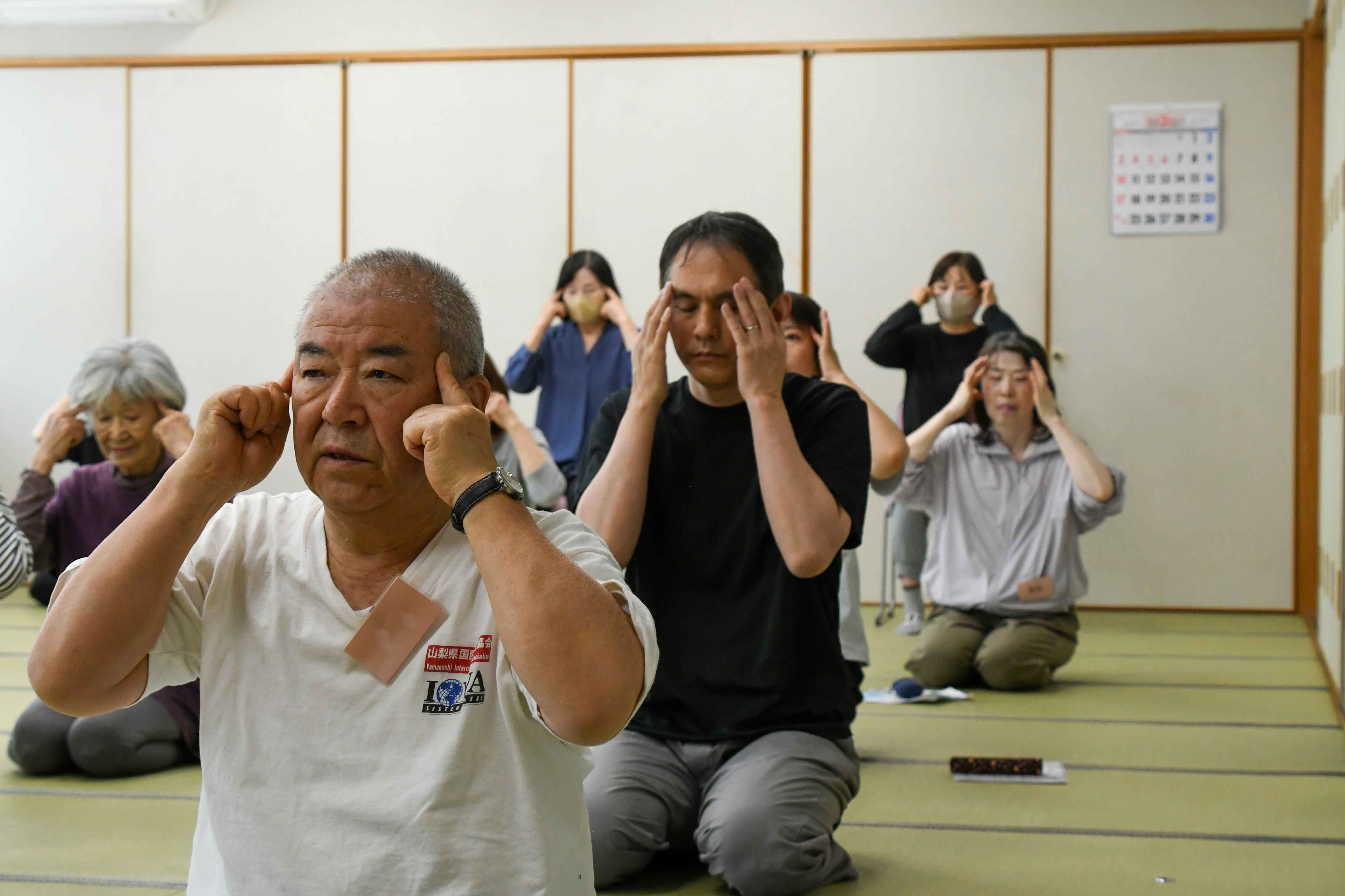 こめかみを刺激する参加者