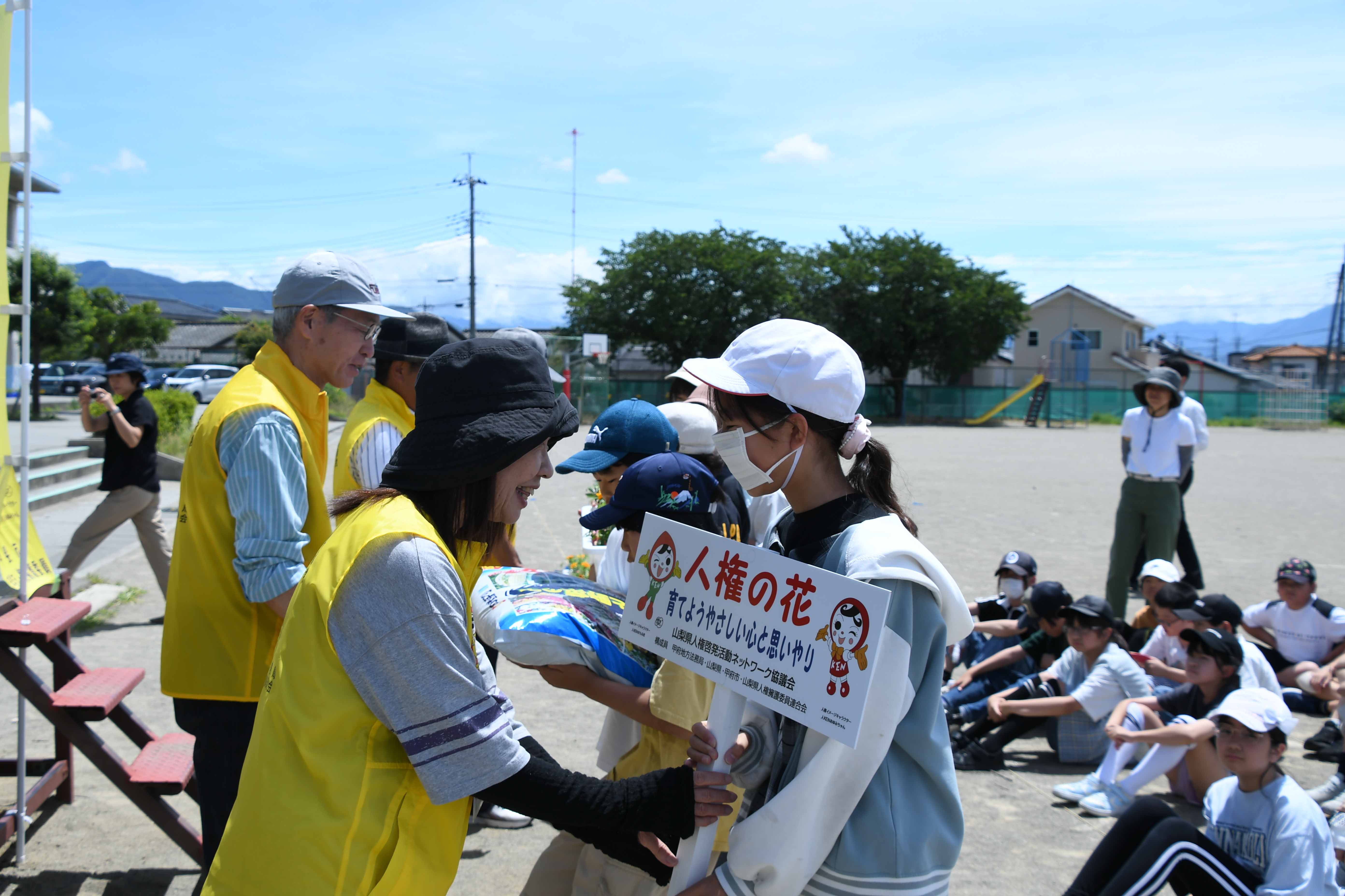 委員から花を受け取る児童代表