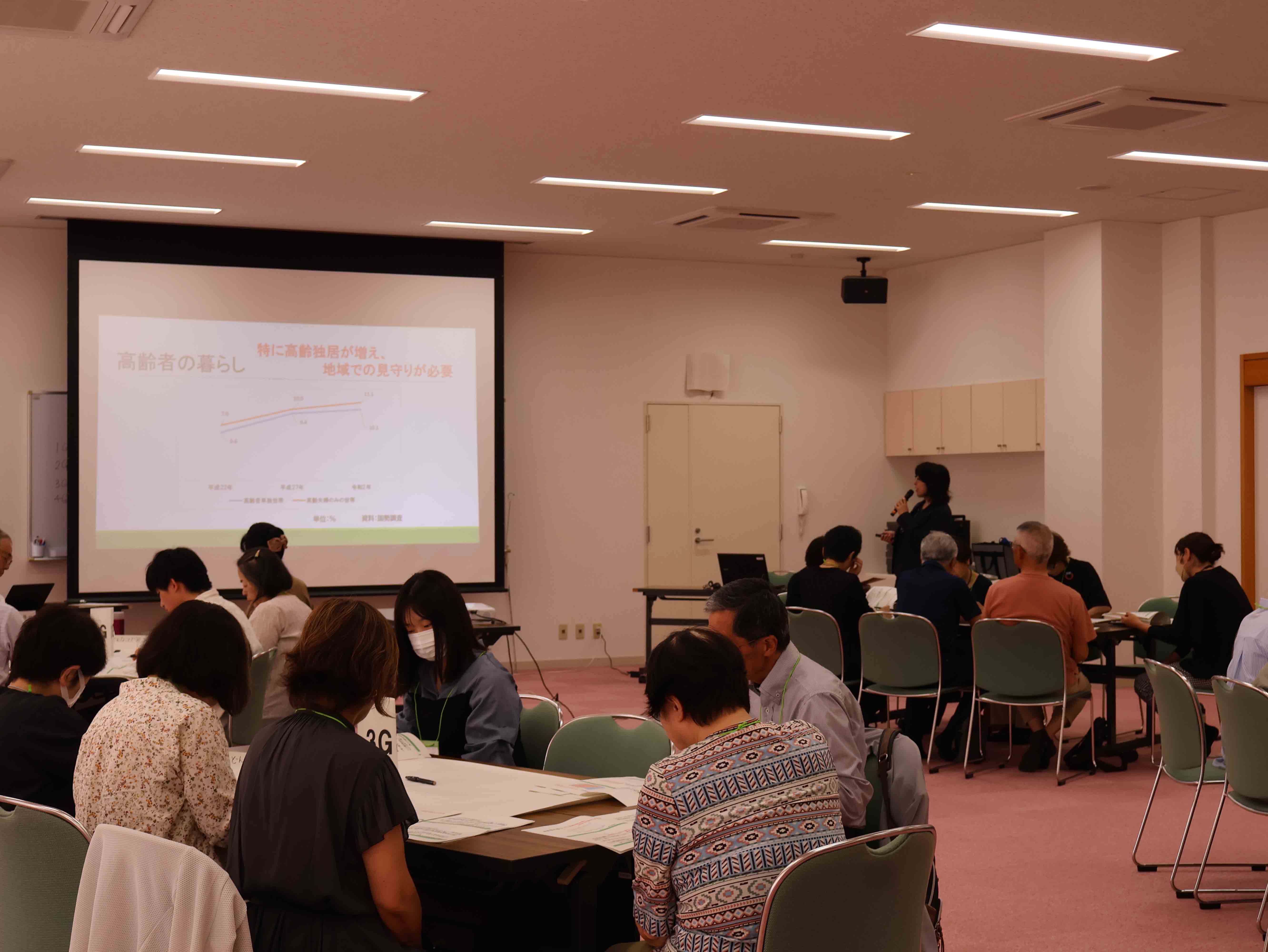 甲斐市の現状について説明する市職員