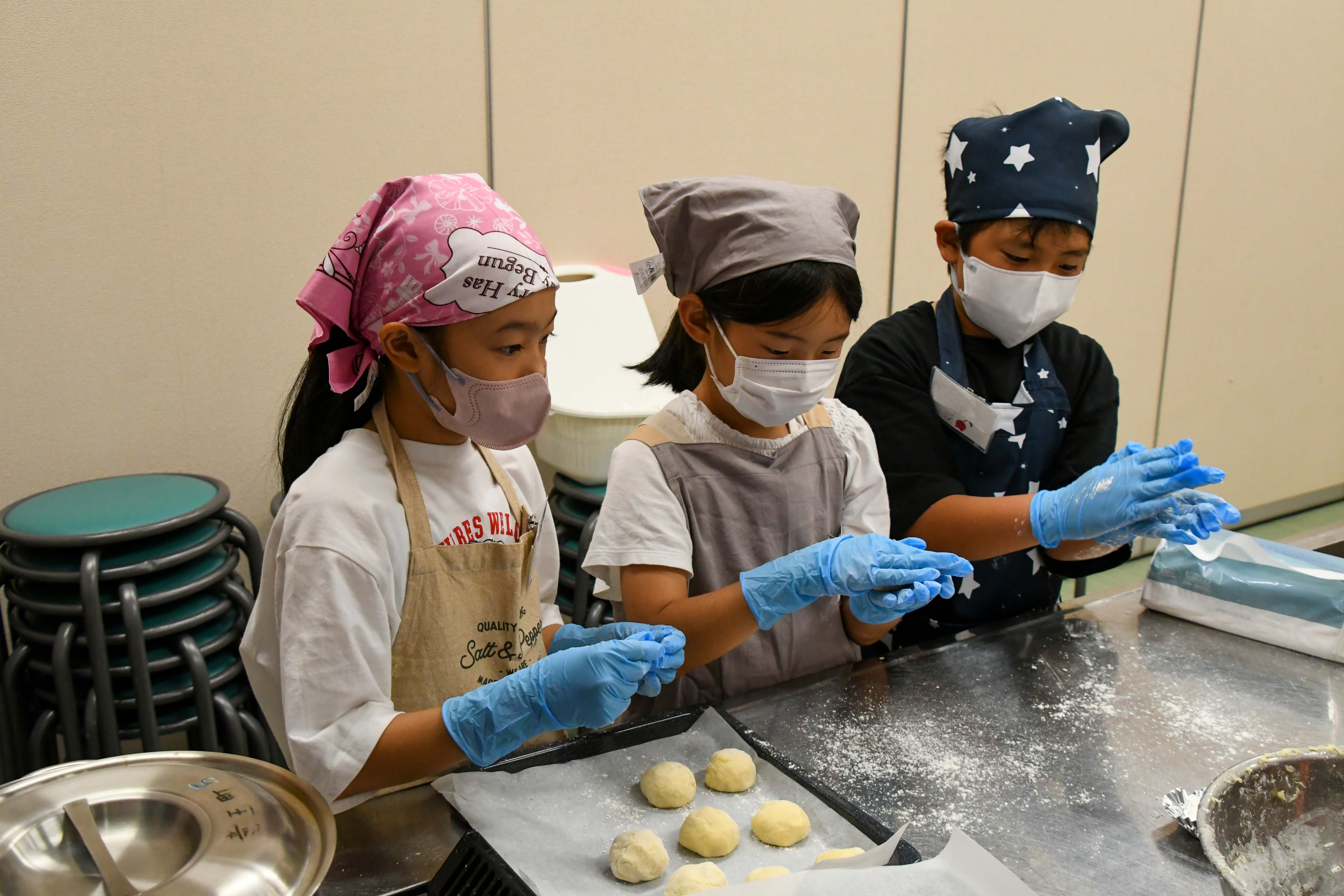 協力してちぎりパンを作る子どもたち