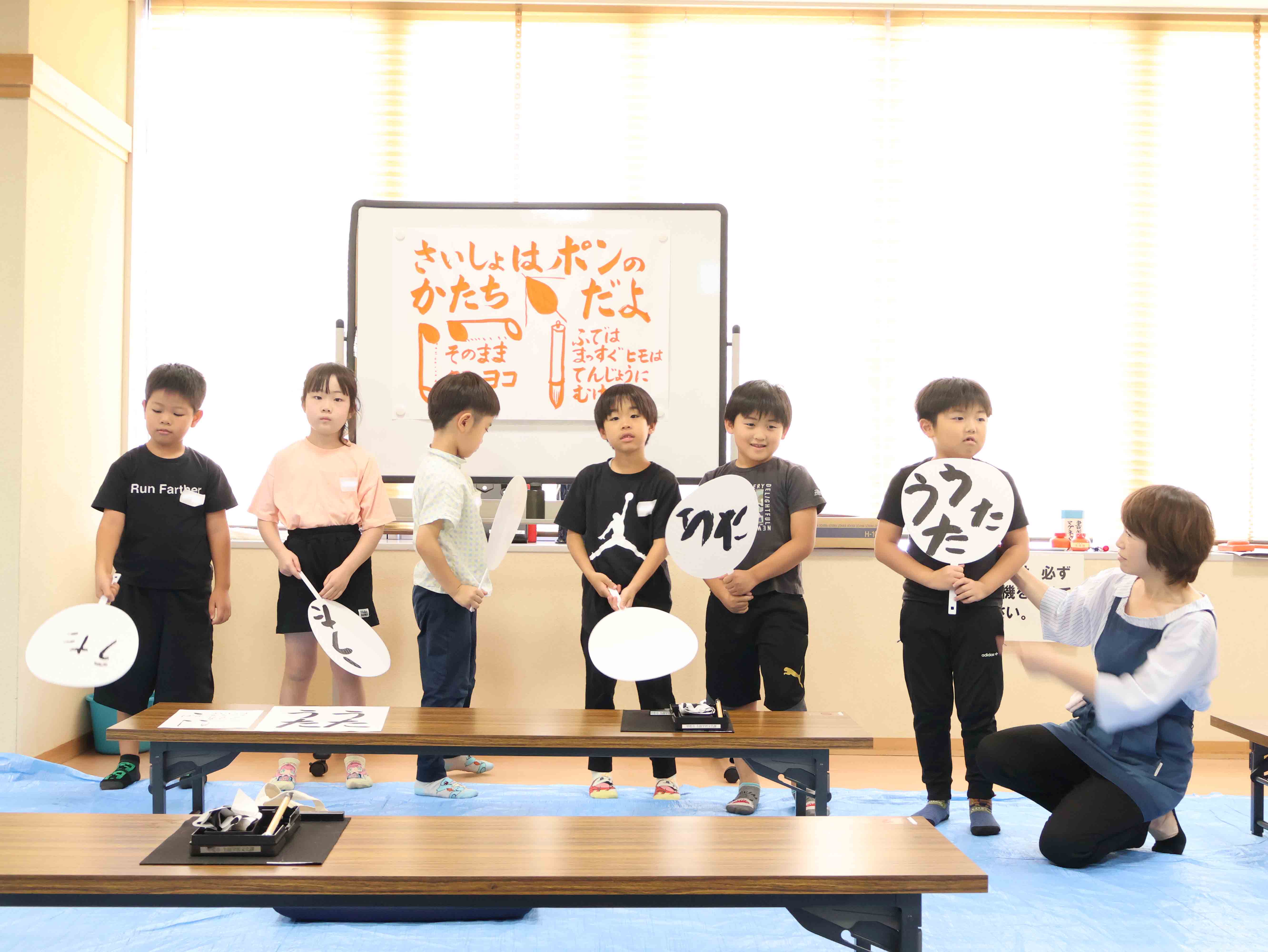 団扇をもって発表する児童たち
