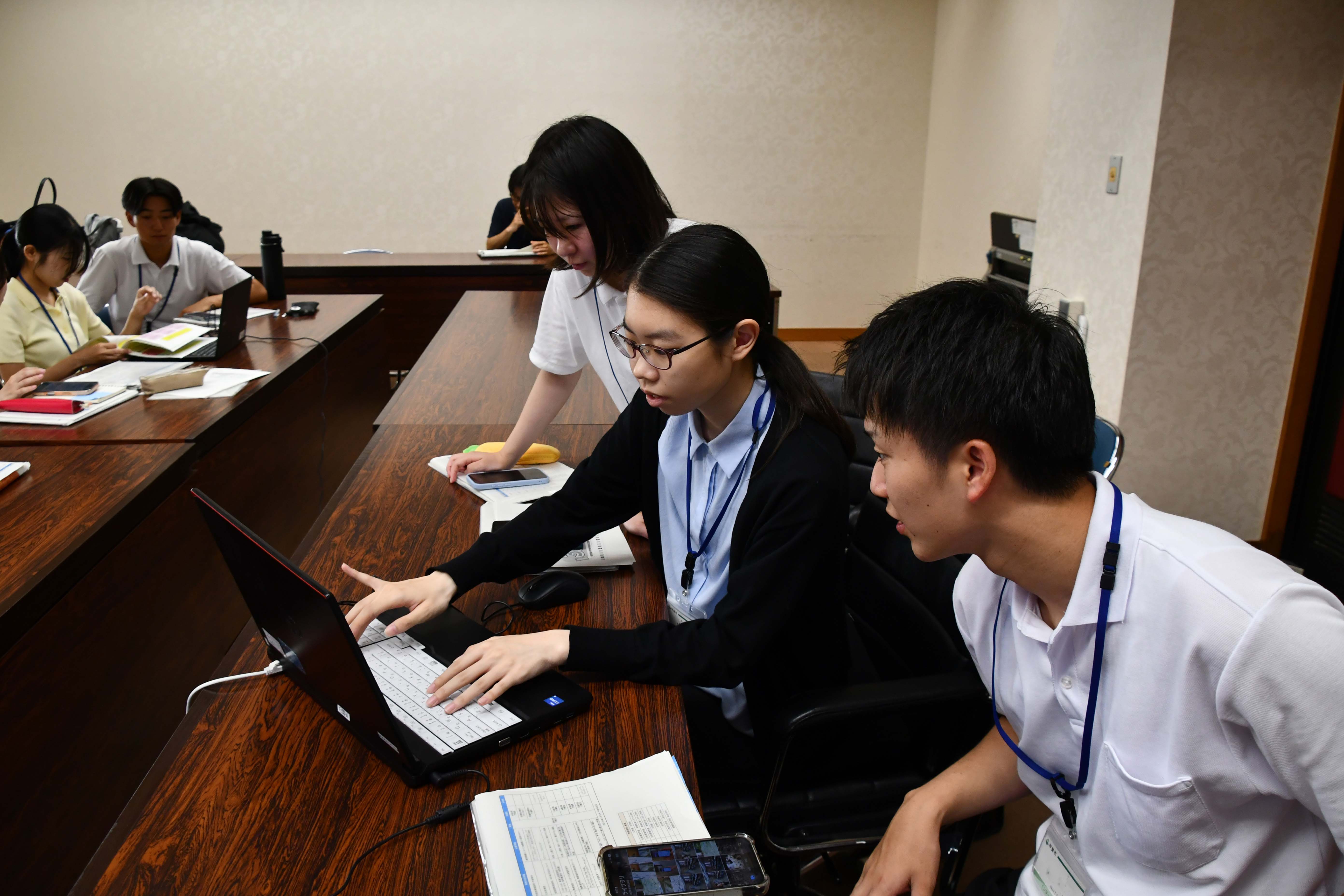 システムを使用し、記事を作成する学生