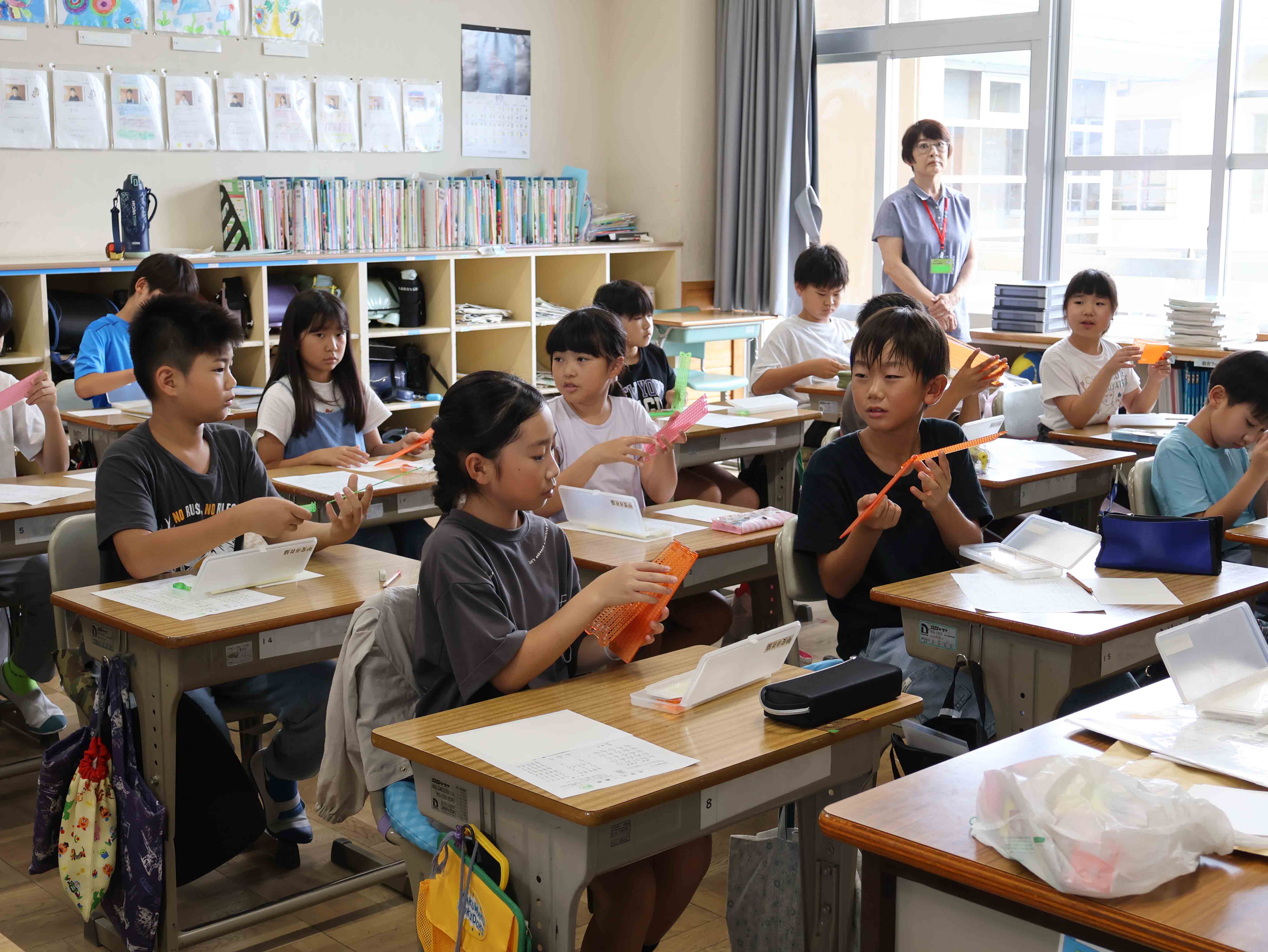 点字機と点筆を持つ児童たち