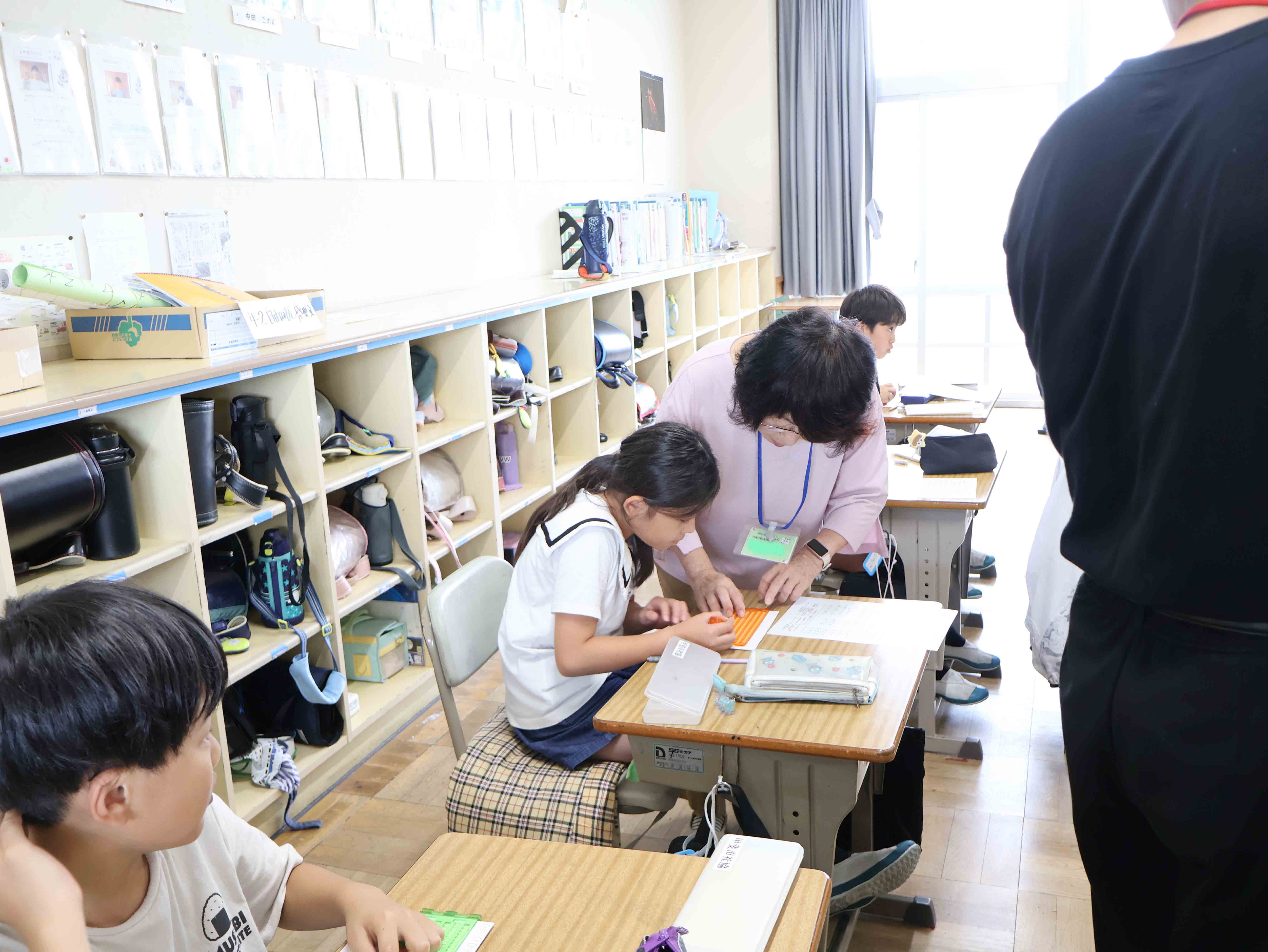 講師に点字の打ち方を教わる児童