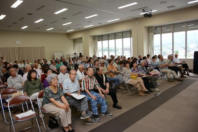 カラオケ大会の観客の写真 みんな椅子に座っています写真2