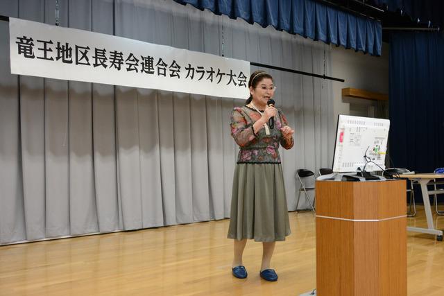 カラオケ大会 女の人がマイクを持って、歌を歌っている写真5